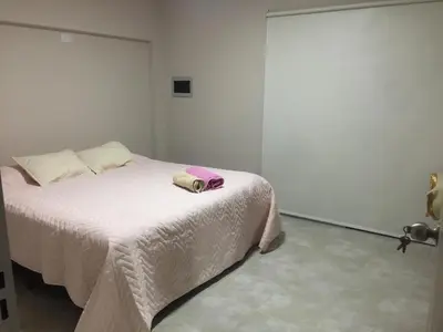 a bedroom with a bed with a pink towel on it at Departamento in Alta Gracia