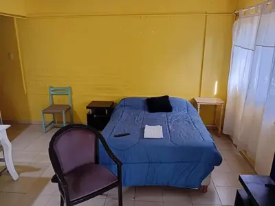 a bedroom with a blue bed and a chair at Depto Alto Verde in Cordoba