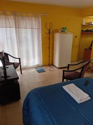 a bedroom with a blue bed and a refrigerator at Depto Alto Verde in Cordoba