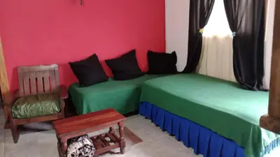 a bedroom with two green beds and a chair at Casa de campo La Mary in Tanti