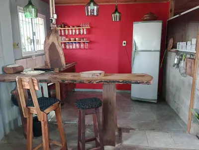 a kitchen with a wooden table and a refrigerator at Casa de campo La Mary in Tanti