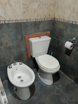a bathroom with a white toilet and a sink at Casa de campo La Mary in Tanti
