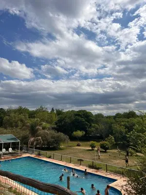 a group of people swimming in a swimming pool at Cabañas Ensueño in Villa Carlos Paz