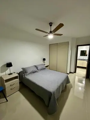 a bedroom with a bed and a ceiling fan at Flat with Pool, Gym & Great Views in Villa Carlos Paz