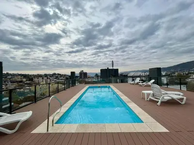 a swimming pool on the roof of a building at Flat with Pool, Gym & Great Views in Villa Carlos Paz
