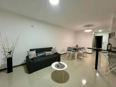 a living room with a black couch and a table at Flat with Pool, Gym & Great Views in Villa Carlos Paz