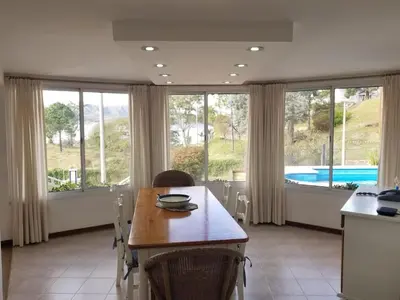 a kitchen with a table and chairs and windows at La Casa del Lago in Villa Santa Cruz del Lago
