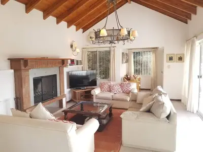 a living room with white furniture and a fireplace at La Casa del Lago in Villa Santa Cruz del Lago