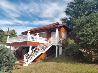 a house with a white balcony on the side of it at La Casa del Lago in Villa Santa Cruz del Lago