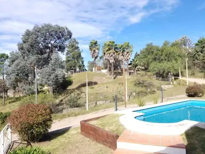 a swimming pool in a yard with palm trees at La Casa del Lago in Villa Santa Cruz del Lago