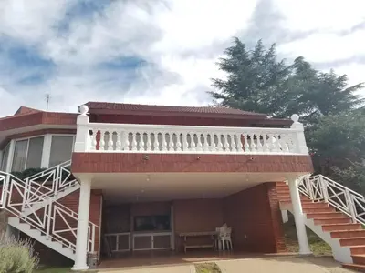 a house with a white balcony on top of it at La Casa del Lago in Villa Santa Cruz del Lago