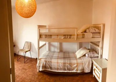 a bedroom with two bunk beds and a chair at Departamento barrio urca in Cordoba
