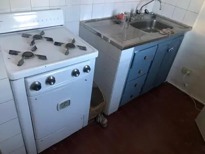 a small kitchen with a stove and a sink at Departamento barrio urca in Cordoba