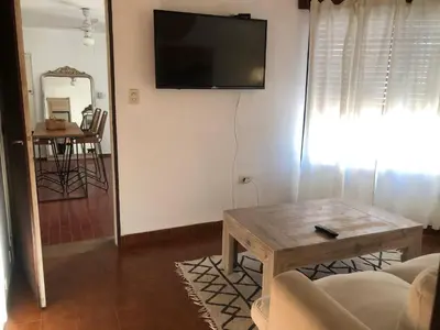 a living room with a table and a tv on the wall at Departamento barrio urca in Cordoba