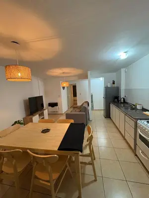 a kitchen and living room with a wooden table and a dining room at Departamento Excelente Ubicación ! in Cordoba