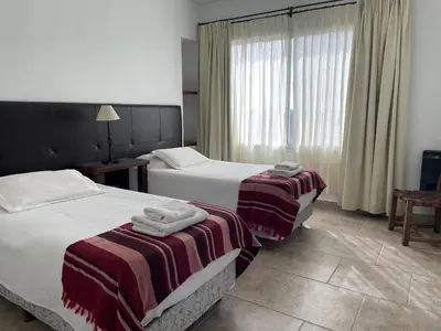 a hotel room with two beds and a window at Las Negritas, Casas de Montaña in La Estancia