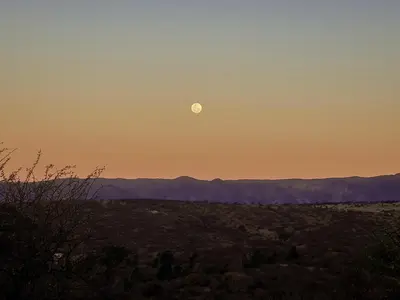 a sunset with the moon in the sky at Las Negritas, Casas de Montaña in La Estancia