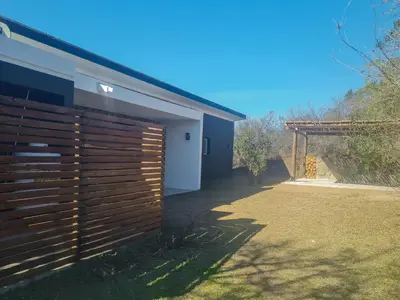a house with a wooden fence next to a yard at Las Negritas, Casas de Montaña in La Estancia