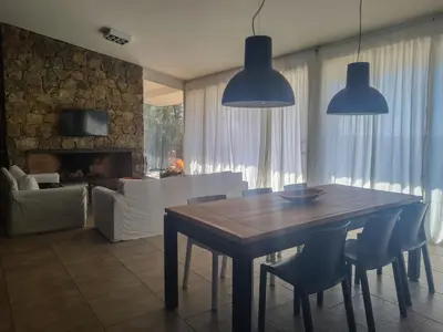 a dining table and chairs in a living room at Las Negritas, Casas de Montaña in La Estancia