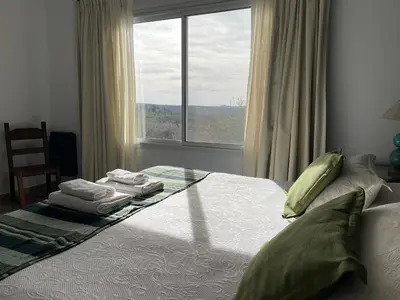 a bedroom with a bed with towels and a window at Las Negritas, Casas de Montaña in La Estancia