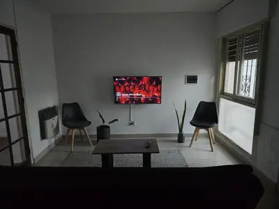a living room with two chairs and a tv on the wall at Departamento - Cerro de las Rosas, Cordoba - 5 personas in Cordoba