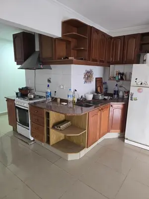 a kitchen with wooden cabinets and a white refrigerator at Departamento - Cerro de las Rosas, Cordoba - 5 personas in Cordoba