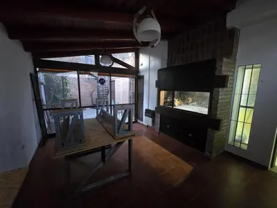 a living room with a fireplace and a wooden table at Departamento - Cerro de las Rosas, Cordoba - 5 personas in Cordoba