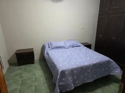 a small bedroom with a bed with a blue comforter at RS Home in Río Cuarto