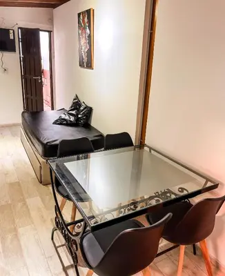 a glass table with chairs and a bed in a room at Cabañas Antartida in Villa Carlos Paz