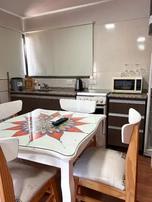 a kitchen with a table and chairs and a microwave at Cabañas Antartida in Villa Carlos Paz