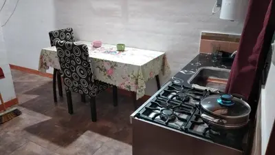 a kitchen with a stove and a table with chairs at Alquiler villa dolores in San Javier