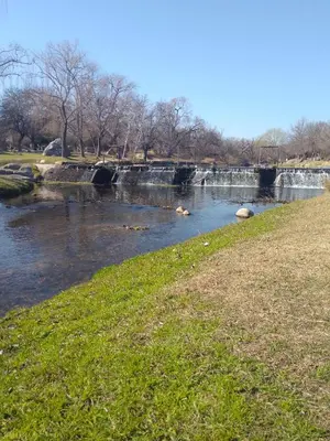a river with a waterfall in a park with green grass at Alquiler villa dolores in San Javier