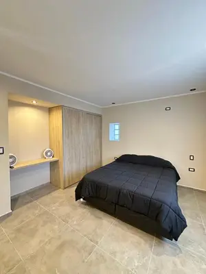 a bedroom with a large bed in a room at Departamentos Sol y Lago in Villa Carlos Paz