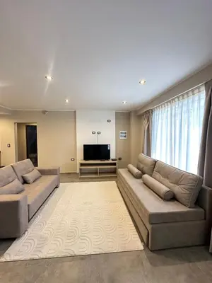 a living room with two couches and a flat screen tv at Departamentos Sol y Lago in Villa Carlos Paz