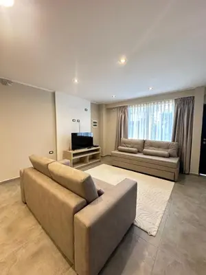 a large living room with a couch and a television at Departamentos Sol y Lago in Villa Carlos Paz