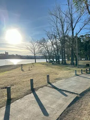 a park with the sun setting in the background at Departamentos Sol y Lago in Villa Carlos Paz