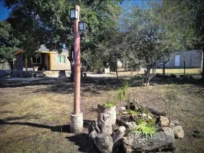a light pole in a yard next to some rocks at Punto Campestre in Cueva de los Pajaritos