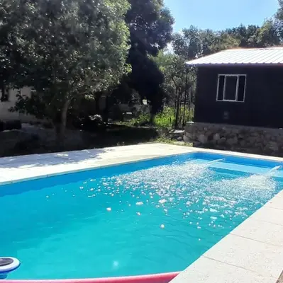 a pool with blue water in front of a house at Punto Campestre in Cueva de los Pajaritos