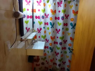 a bathroom with a sink and a shower curtain with butterflies at Cabañas Mi Capricho in Santa Rosa de Calamuchita