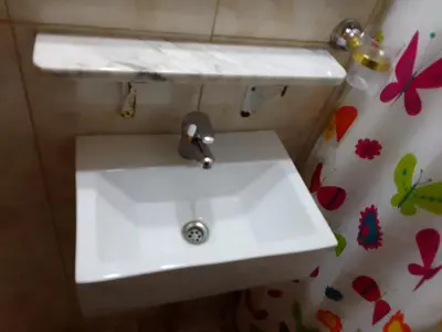 a white sink in a bathroom with a shower curtain at Cabañas Mi Capricho in Santa Rosa de Calamuchita