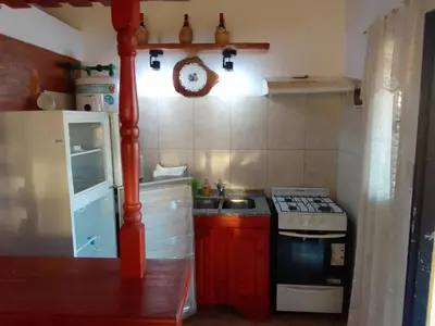 a small kitchen with a stove and a sink at Cabañas Mi Capricho in Santa Rosa de Calamuchita