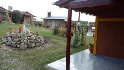 a yard with a pile of rocks next to a house at Cabañas Mi Capricho in Santa Rosa de Calamuchita