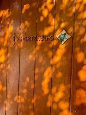 a wooden wall with a sign on it and shadows at Alta Montaña Hosteria&Apart in Los Hornillos