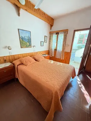 a bedroom with a bed with an orange bedspread at Alta Montaña Hosteria&Apart in Los Hornillos