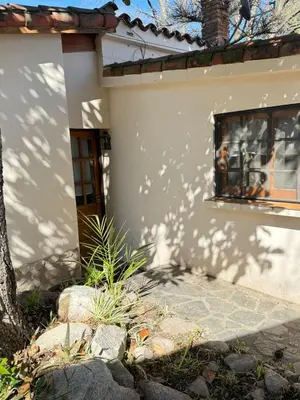 a white house with a window and a tree at Alta Montaña Hosteria&Apart in Los Hornillos