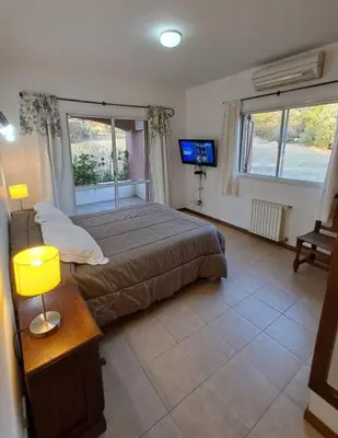 a bedroom with a bed and a television in it at Casa en las sierras de Merlo in Merlo
