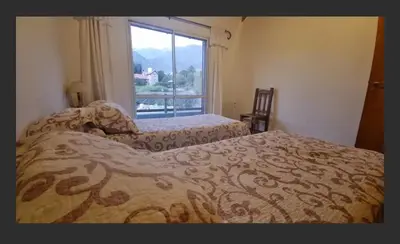 a bedroom with two beds and a large window at Casa en las sierras de Merlo in Merlo