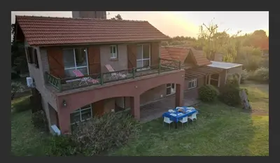 a large house with a table in front of it at Casa en las sierras de Merlo in Merlo