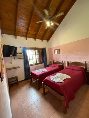 a bedroom with two beds and a ceiling fan at Posada in Merlo