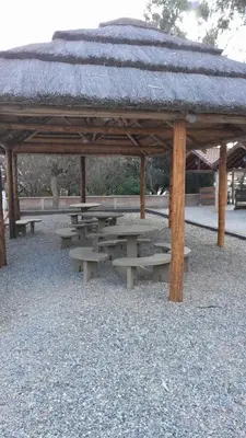 a picnic shelter with picnic tables in a park at Posada in Merlo